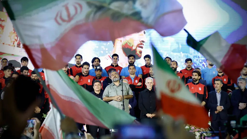 Supporters-gather-while-a-man-performs-in-front-of-Iran-National-football-team-players-head-coach-and-other-officials-gathered-on-stage-during-a-ceremony-at-Enqelab-Square-in-Tehran-Iran-on-May-13-2026-The-ceremony-was-organized-to-unveil-the-team-s-new-kit-and-provide-a-public-send-off-from-supporters-ahead-of-the-2026-FIFA-World-Cup