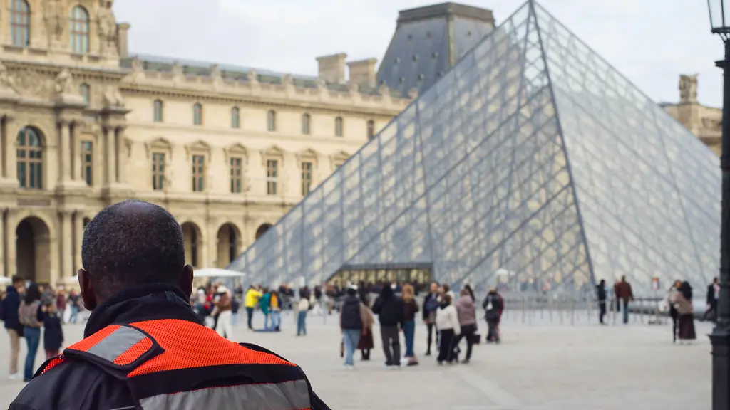 France-Paris-2025-11-03-A-private-security-guard-watches-the-many-visitors-entering-the-pyramid-to-visit-the-Louvre-Museum-On-Sunday-10-October-2025-four-criminals-stole-priceless-jewellery-while-the-museum-was-open-With-9-million-visitors-the-Louvre-is-the-most-visited-museum-in-the-world-Photograph-by-Eric-Broncard-Hans-Lucas-France-Paris-2025-11-03-Un-agent-de-securite-prive-regarde-les-nombreux-visiteurs-qui-rentrent-dans-la-pyramide-pour-visiter-le-musee-du-Louvre-Le-dimanche-10-octobre-2025-4-malfaiteurs-ont-derobe-pendant-louverture-du-musee-des-bijoux-dune-valeur-inestimable-Avec-ces-9-millions-de-visiteurs-le-Louvre-est-le-musee-le-plus-visite-au-monde