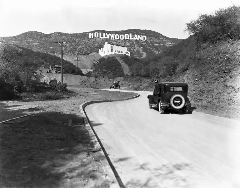 A-sign-advertises-the-opening-of-the-Hollywoodland-housing-development-in-the-hills-on-Mulholland-Drive-overlooking-Los-Angeles-Hollywood-Los-Angeles-California-circa-1924-The-white-building-below-the-sign-is-the-Kanst-Art-Gallery-which-opened-on-April-1-1924