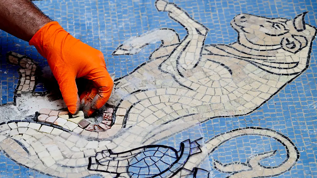 Restorer-Gianluca-Galli-works-on-the-mosaic-of-the-bull-during-the-restoration-in-the-Galleria-Vittorio-Emanuele-II-donwtown-Milan-on-May-28-2026-Because-of-constant-pirouettes-on-the-heel-made-by-tourists-visiting-Milan-the-pink-tesserae-that-make-up-its-testicles-have-been-worn-down-forming-a-small-crater-city-authorities-said-in-a-statement-The-beige-bull-mosaic-representing-Turin-the-then-capital-of-Italy-is-part-of-the-flooring-in-the-19th-century-shopping-arcade-near-Milan-s-famous-Duomo-cathedral