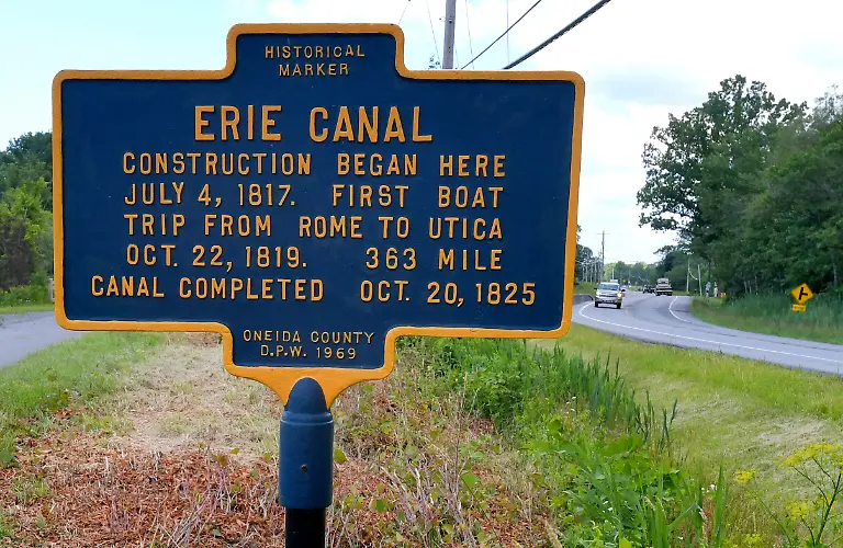 In-this-June-28-2017-photo-a-sign-on-route-49-46-in-Rome-N-Y-marks-the-spot-where-digging-for-construction-on-the-Erie-Canal-began-This-Fourth-of-July-marks-the-200th-anniversary-of-the-ceremonial-first-digging-for-the-construction-of-the-Erie-Canal-a-363-mile-waterway-that-would-change-history