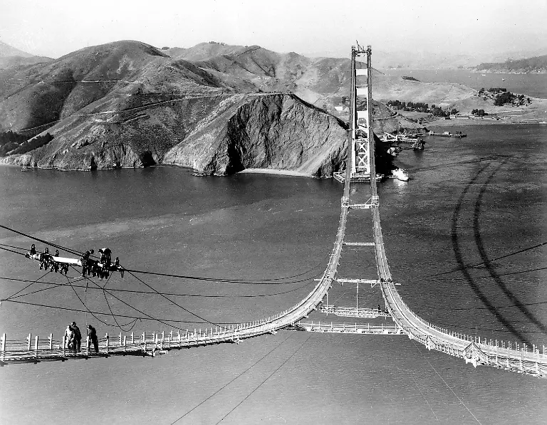 File-In-an-Oct-25-1935-file-photo-workers-complete-the-catwalks-for-the-Golden-Gate-Bridge-prior-to-spinning-the-bridge-cables-during-construction-in-San-Francisco-The-bridge-was-heralded-as-an-engineering-marvel-when-it-opened-in-1937-It-was-the-world-s-longest-suspension-span-and-had-been-built-across-a-strait-that-critics-said-was-too-treacherous-to-be-bridged-As-the-iconic-span-approaches-its-75th-anniversary-the-engineers-who-have-overseen-it-all-these-years-say-keeping-it-up-and-open-has-been-a-feat-unto-itself