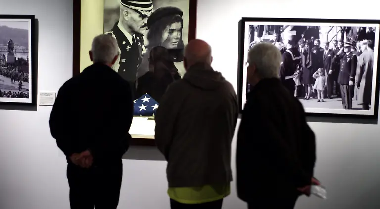 epa03961392-Visitors-look-over-the-the-flag-that-draped-the-casket-of-United-States-President-John-F-Kennedy-s-casket-during-his-funeral-at-a-special-exhibit-in-the-John-F-Kennedy-Library-and-Museum-in-Boston-Massachusetts-USA-22-November-2013-50-years-ago-then-United-States-President-Kennedy-was-assassinated-in-Dallas-and-citizens-around-the-nation-are-marking-the-anniversary-with-services
