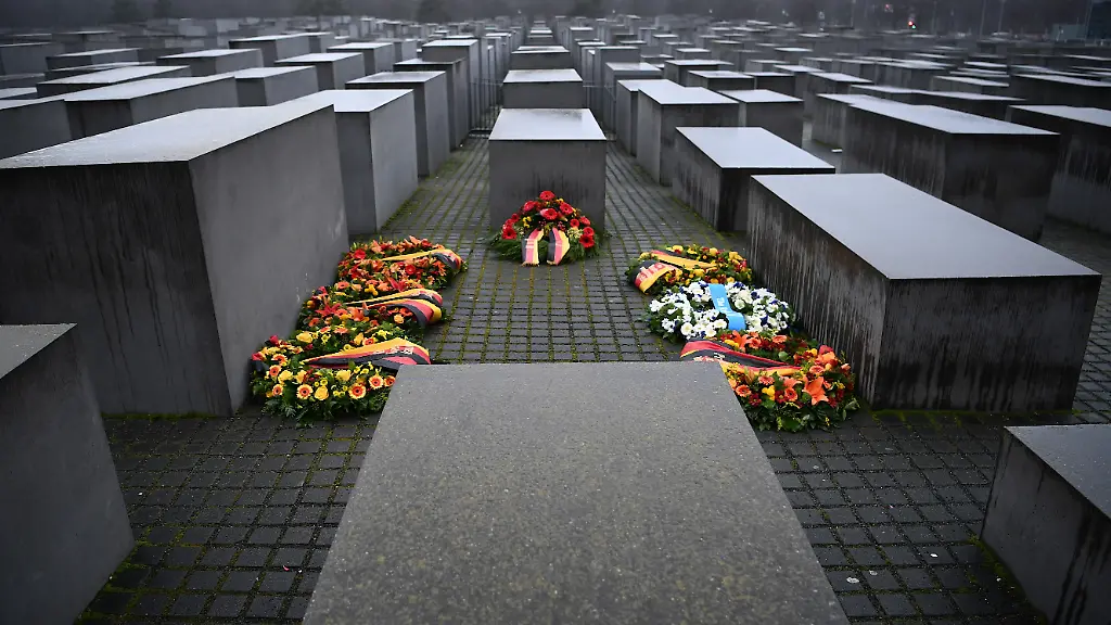 Blumenkraenze-liegen-anlaesslich-des-Holocaust-Gedenktages-zum-Gedenken-an-die-Opfer-des-Nationalsozialismus-am-Mahnmal-fuer-die-ermordeten-Juden-Europas-das-auch-Holocaust-Denkmal-genannt-wird-zwischen-den-Stelen
