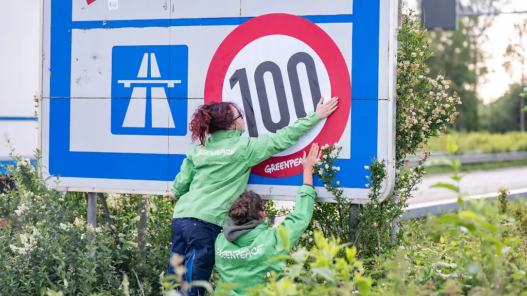 Greenpeace-Aktion-fuer-ein-Tempolimit-auf-deutschen-Autobahnen-Auf-der-A4-bei-Aachen-ueberkleben-zwei-Aktivistinnen-von-Greenpeace-die-Richtgeschwindigkeit-von-130-mit-einem-Tempo-100-Geschwindigkeitsgebot-Die-Aktion-wurde-an-mehreren-deutschen-Grenzuebergaengen-gleichzeitig-durchgefuehrt