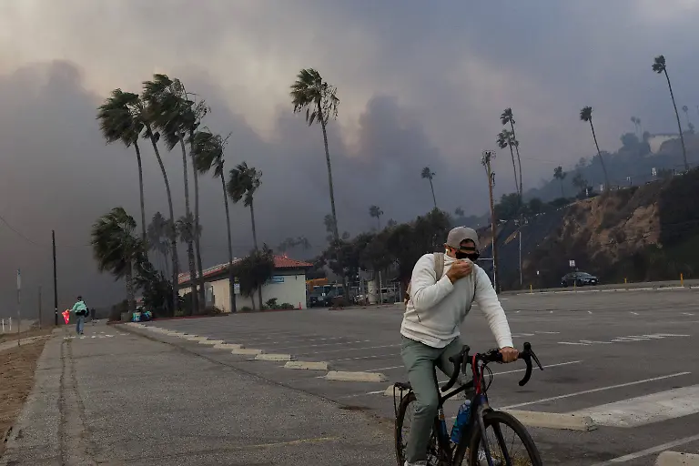 News-Bilder-des-Tages-PACIFIC-PALISADES-CA-JANUARY-07-A-resident-rides-through-smoke-from-a-brush-fire-pushed-by-gusting-Santa-Ana-winds-on-January-7-2025-in-Pacific-Palisades-Los-Angeles-California-A-fire-in-the-Pacific-Palisades-area-of-Los-Angeles-has-forced-some-residents-to-evacuate-amid-life-threatening-and-destructive-winds