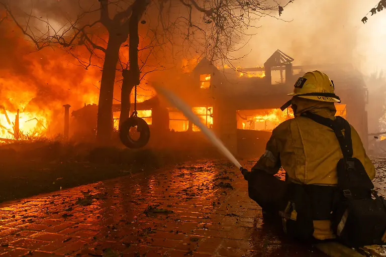 January-8-2025-Malibu-California-USA-A-firefighter-battles-a-home-in-flames-in-Pacific-Palisades-during-the-second-day-of-the-Palisades-Fire