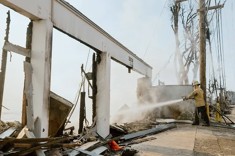 California-Wildfires-Malibu-January-09-A-firefighter-works-with-water-hoses-near-houses-burned-down-in-the-Palisades-Fire-along-the-Pacific-Coast-Highway-in-Malibu-California-January-9-2025-Massive-wildfires-that-engulfed-whole-neighborhoods-and-displaced-thousands-in-Los-Angeles-remained-totally-uncontained-January-9-2025-authorities-said-as-US-National-Guard-soldiers-readied-to-hit-the-streets-to-help-quell-disorder