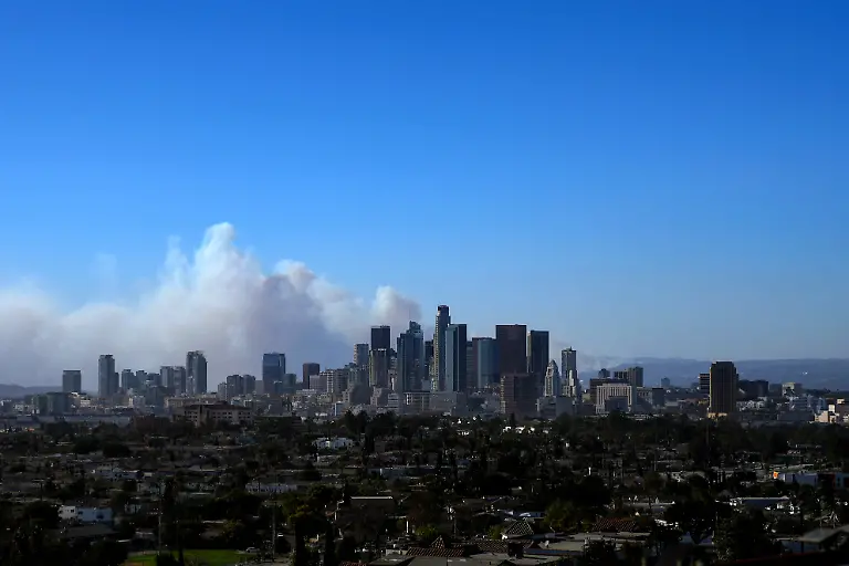 LOS-ANGELES-CALIFORNIA-JANUARY-7-The-city-skyline-is-seen-as-the-Palisades-Fire-burns-amid-a-powerful-windstorm-on-January-7-2025-in-Pacific-Palisades-California-The-fast-moving-wildfire-is-threatening-homes-in-the-coastal-neighborhood-amid-intense-Santa-Ana-Winds-and-dry-conditions-in-Southern-California