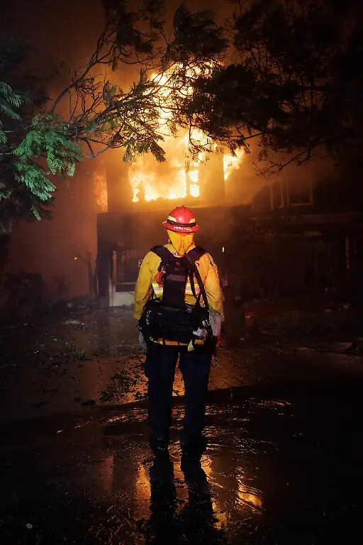 A-firefighter-watches-a-home-burn-as-the-Palisades-Fire-rapidly-spreads-through-the-Pacific-Palisades-neighborhood-in-Los-Angeles-Calif-on-Tuesday-Jan-7-2025-The-fire-has-destroyed-dozens-of-homes-and-prompting-evacuation-orders-for-about-30-000-people