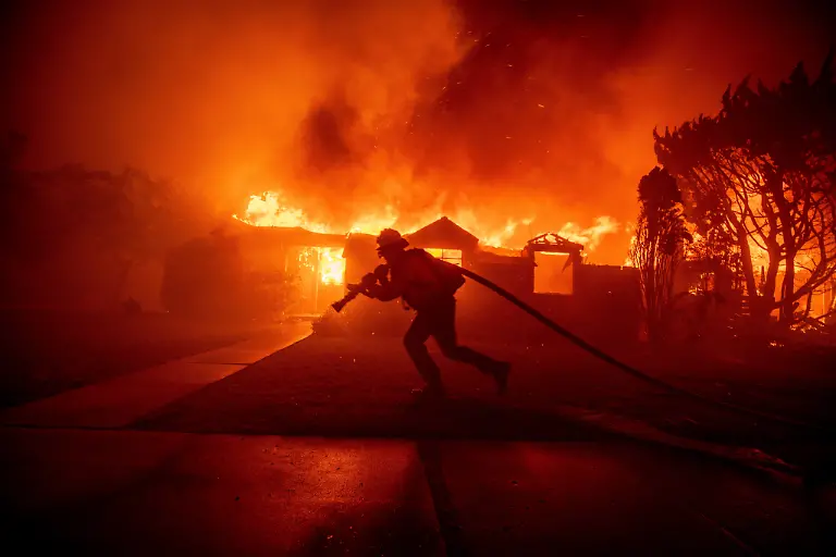 A-firefighter-battles-the-Palisades-Fire-as-it-burns-a-structure-in-the-Pacific-Palisades-neighborhood-of-Los-Angeles-Tuesday-Jan-7-2025