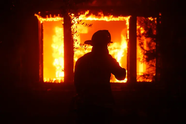 A-firefighter-is-silhouetted-in-front-of-a-burning-structure-as-the-Palisades-Fire-sweeps-through-in-the-Pacific-Palisades-neighborhood-of-Los-Angeles-Tuesday-Jan-7-2025