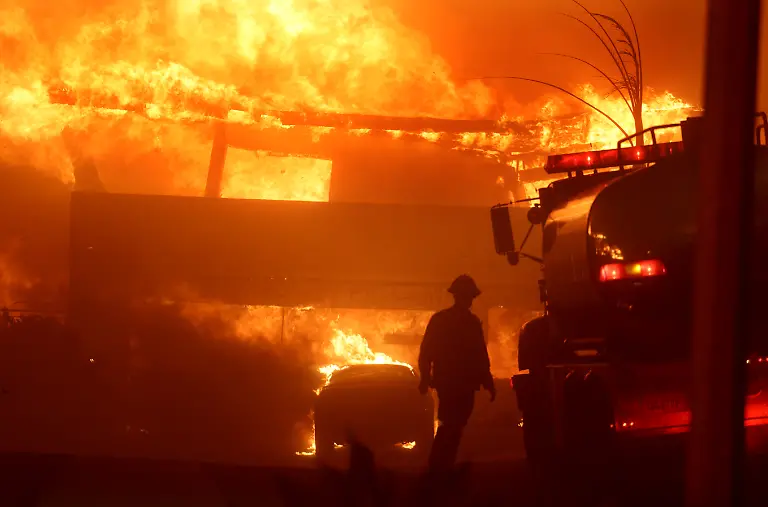 Malibu-California-January-8-2025-A-Torrance-firefighter-watches-as-a-house-burns-from-the-Palisades-Fire-on-Shoreheights-Drive-in-Pacific-Palisades-Tuesday