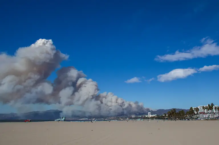 LOS-ANGELES-CALIFORNIA-JANUARY-7-A-firefighting-aircraft-drops-the-fire-retardant-Phos-Chek-as-the-Palisades-Fire-burns-amid-a-powerful-windstorm-on-January-7-2025-in-the-Pacific-Palisades-neighborhood-of-Los-Angeles-California-The-fast-moving-wildfire-is-threatening-homes-in-the-coastal-neighborhood-amid-intense-Santa-Ana-Winds-and-dry-conditions-in-Southern-California