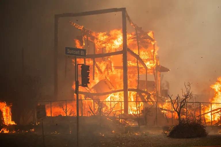 LOS-ANGELES-CALIFORNIA-JANUARY-8-Flames-from-the-Palisades-Fire-burn-a-building-on-Sunset-Boulevard-amid-a-powerful-windstorm-on-January-8-2025-in-the-Pacific-Palisades-neighborhood-of-Los-Angeles-California-Fueled-by-intense-Santa-Ana-Winds-the-Palisades-Fire-has-grown-to-over-15-000-acres-and-30-000-people-have-been-ordered-to-evacuate-while-a-second-major-fire-continues-to-burn-near-Eaton-Canyon-in-Altadena