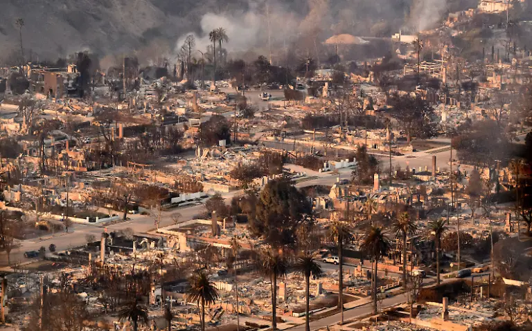 In-this-aerial-view-taken-from-a-helicopter-homes-burned-from-the-Palisade-fire-smolder-near-the-Pacific-Palisades-neighborhood-of-Los-Angeles-California-on-January-9-2025-Massive-wildfires-that-engulfed-whole-neighborhoods-and-displaced-thousands-in-Los-Angeles-remained-totally-uncontained-January-9-2025-authorities-said-as-US-National-Guard-soldiers-readied-to-hit-the-streets-to-help-quell-disorder-Swaths-of-the-United-States-second-largest-city-lay-in-ruins-with-smoke-blanketing-the-sky-and-an-acrid-smell-pervading-almost-every-building