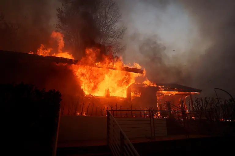 LOS-ANGELES-CALIFORNIA-JANUARY-7-Flames-from-the-Palisades-Fire-burn-a-home-on-January-7-2025-in-the-Pacific-Palisades-neighborhood-of-Los-Angeles-California-The-fast-moving-wildfire-is-threatening-homes-in-the-coastal-neighborhood-amid-intense-Santa-Ana-Winds-and-dry-conditions-in-Southern-California