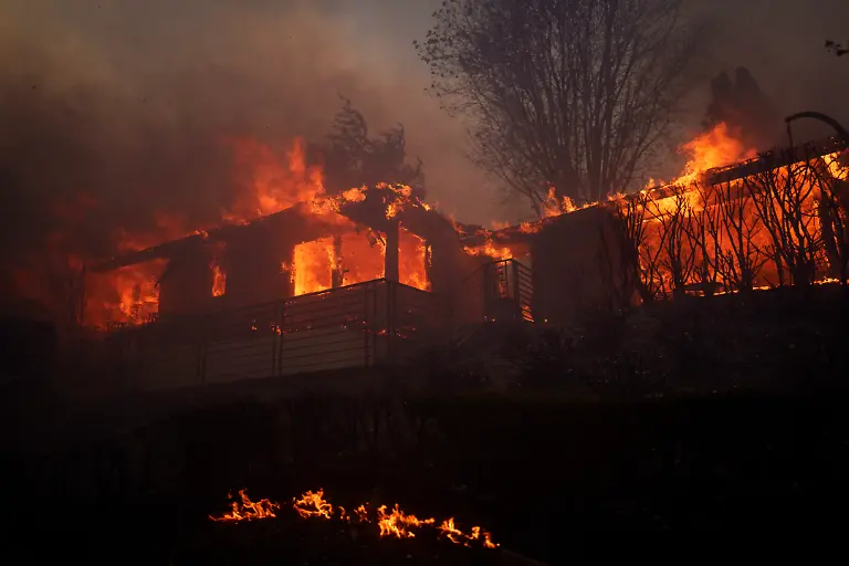 LOS-ANGELES-CALIFORNIA-JANUARY-7-Flames-from-the-Palisades-Fire-burn-a-home-on-January-7-2025-in-the-Pacific-Palisades-neighborhood-of-Los-Angeles-California-The-fast-moving-wildfire-is-threatening-homes-in-the-coastal-neighborhood-amid-intense-Santa-Ana-Winds-and-dry-conditions-in-Southern-California