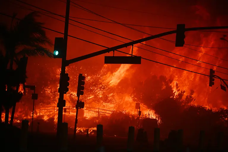 Flames-overtake-the-intersection-of-Temescal-Canyon-and-Pacific-Coast-Highway-Fire-at-the-Palisades-Fire-in-Pacific-Palisades-California-on-January-7-2025-A-fast-moving-wildfire-in-a-Los-Angeles-suburb-burned-buildings-and-sparked-panic-with-thousands-ordered-to-evacuate-January-7-2025-as-life-threatening-winds-whipped-the-region-Frightened-residents-abandoned-their-cars-on-one-of-the-only-roads-in-and-out-of-the-upscale-Pacific-Palisades-area-fleeing-on-foot-from-the-770-acre-310-hectare-blaze-engulfing-an-area-crammed-with-multi-million-dollar-homes-in-the-Santa-Monica-Mountains