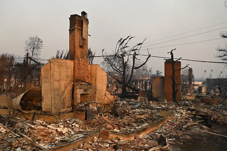 Chimneys-stand-amid-the-remains-of-homes-after-the-passage-of-the-Palisades-Fire-in-Pacific-Palisades-California-on-January-8-2025-At-least-five-people-have-been-killed-in-wildfires-rampaging-around-Los-Angeles-officials-said-on-January-8-with-firefighters-overwhelmed-by-the-speed-and-ferocity-of-multiple-blazes