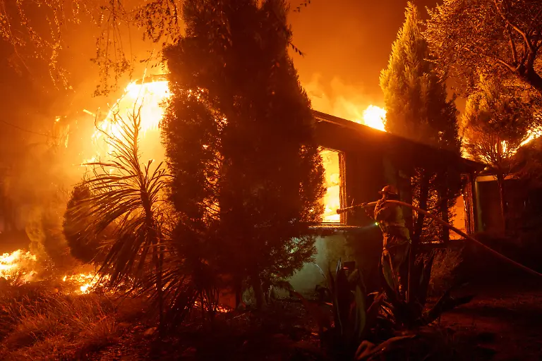 LOS-ANGELES-CALIFORNIA-JANUARY-7-Firefighters-battle-flames-from-the-Palisades-Fire-on-January-7-2025-in-the-Pacific-Palisades-neighborhood-of-Los-Angeles-California-The-fast-moving-wildfire-is-threatening-homes-in-the-coastal-neighborhood-amid-intense-Santa-Ana-Winds-and-dry-conditions-in-Southern-California