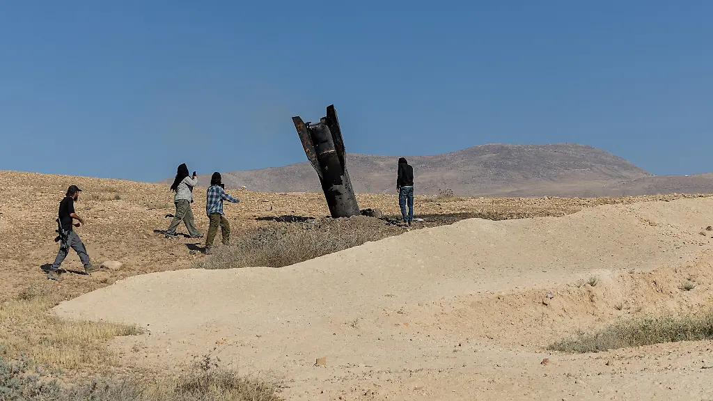 Israeli-settlers-stand-next-to-part-of-a-missile-protruding-from-the-ground-following-strikes-from-Iran-in-the-central-Israeli-occupied-West-Bank-June-8-2026-REUTERS-Naama-Stern-ISRAEL-OUT