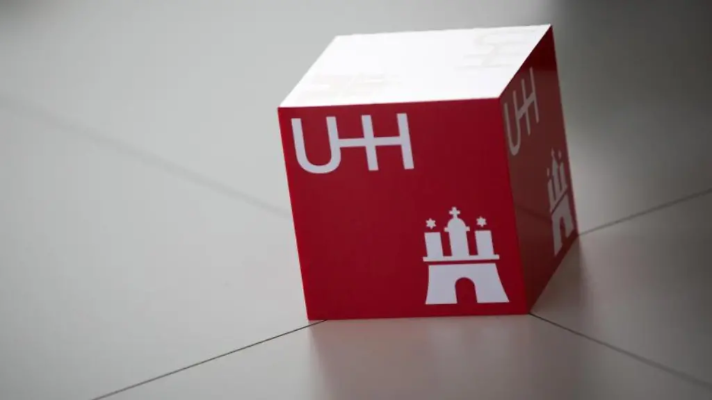 Ein-Wuerfel-mit-dem-Logo-der-Universitaet-Hamburg-UH-liegt-auf-einem-Tisch