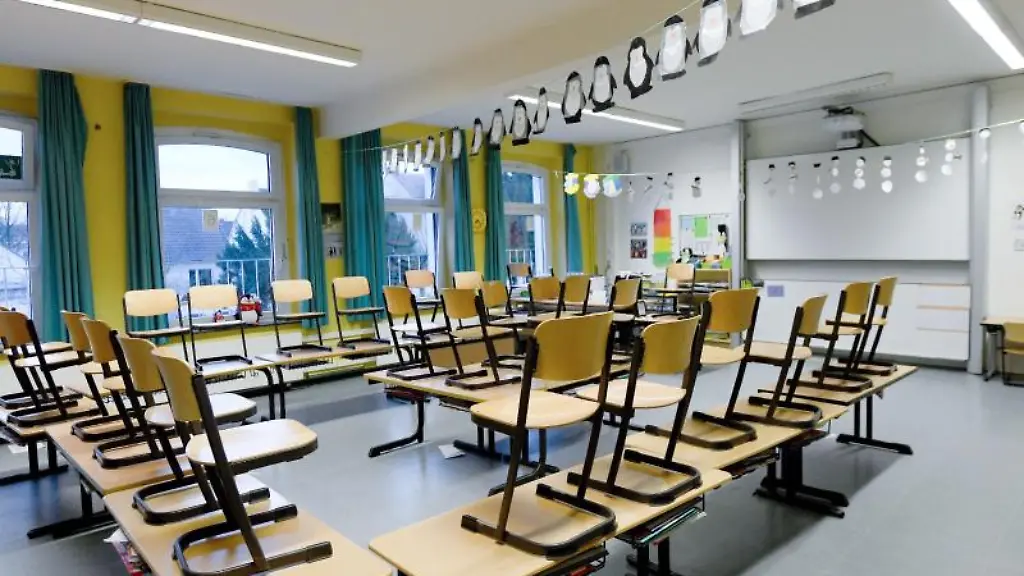 Stuehle-stehen-in-einem-Klassenzimmer-in-einer-Grundschule-auf-den-Tischen