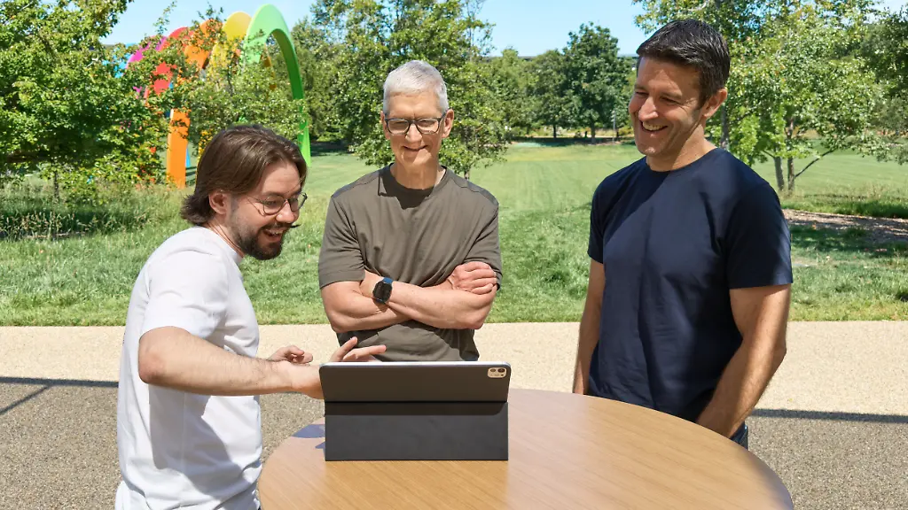 Die-am-07-06-2026-von-Apple-zur-Verfuegung-gestellte-Aufnahme-zeigt-Anton-Baranov-l-aus-Frankfurt-dabei-wie-er-Apple-Chef-Tim-Cook-M-und-dem-kuenftigen-Konzernlenker-John-Ternus-r-seine-App-Pitch-Coach-zeigt-Die-Anwendung-soll-helfen-Praesentationen-zu-ueben-Baranov-wurde-vor-Beginn-der-Apple-Entwicklerkonferenz-WWDC-als-Gewinner-eines-Programmier-Wettbewerbs-fuer-Studenten-gewuerdigt