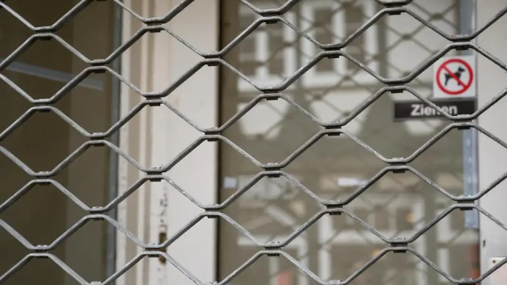 Ein-leerer-Geschaeftsraum-ist-mit-einem-Eisengitter-verriegelt