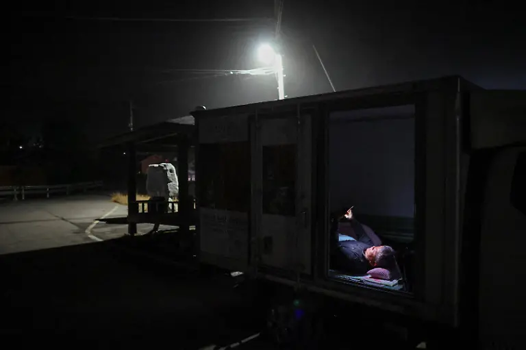 Park-Gyeong-je-65-a-migratory-beekeeper-checks-the-weather-forecast-for-the-next-day-as-he-goes-to-sleep-inside-his-truck-after-work-in-Okcheon-South-Korea-May-13-2026-Park-moves-his-bees-around-the-country-stacked-on-the-back-of-three-trucks-and-a-van-travelling-mostly-in-the-evening-while-the-bees-sleep-Beekeepers-exchange-information-about-where-flowers-are-in-bloom-and-where-conditions-are-good-to-figure-out-the-best-honey-making-routes-he-said-REUTERS-Kim-Hong-Ji-SEARCH-HONG-JI-SOUTH-KOREA-BEES-FOR-THIS-STORY-SEARCH-WIDER-IMAGE-FOR-ALL-STORIES