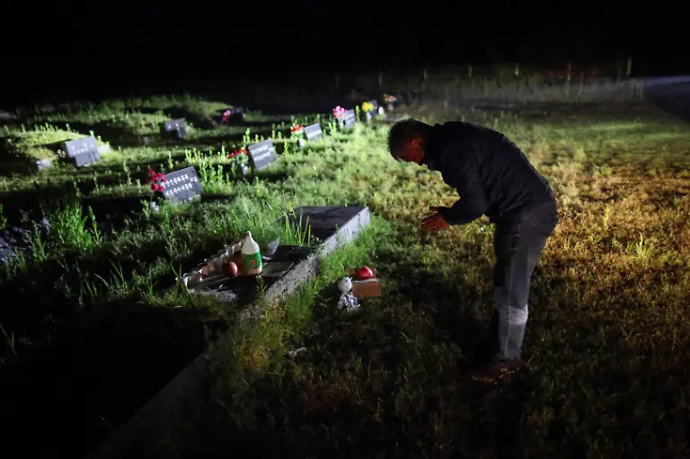 Park-Gyeong-je-65-a-migratory-beekeeper-pays-silent-tribute-at-an-acquaintance-s-family-grave-site-where-he-received-permission-from-the-family-to-keep-hives-as-a-second-location-for-migratory-beekeeping-before-unloading-hives-in-Okcheon-South-Korea-May-12-2026-While-Park-used-to-make-four-trips-across-South-Korea-to-harvest-black-locust-honey-as-a-result-of-premature-blooming-he-now-makes-only-two-and-honey-production-takes-place-on-only-one-to-two-months-of-the-year-Compared-to-the-1990s-or-early-2000s-the-honey-harvest-has-decreased-by-about-70-percent-he-said-REUTERS-Kim-Hong-Ji-SEARCH-HONG-JI-SOUTH-KOREA-BEES-FOR-THIS-STORY-SEARCH-WIDER-IMAGE-FOR-ALL-STORIES