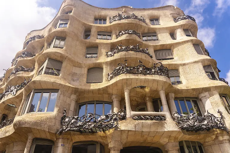 Schmiedeeiserne-Balkone-und-wellenfoermige-Fassade-der-Casa-Mila-eines-beruehmten-modernistischen-Gebaeudes-in-Barcelona-das-von-Antoni-Gaudi-entworfen-wurde