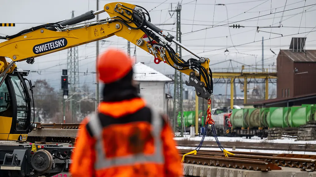 Ein-Mann-mit-Warnweste-und-Helm-steht-an-einer-Baustelle-am-Bahnhof-Die-Deutsche-Bahn-beginnt-die-Generalsanierung-am-Freitag-6-Februar-Die-Arbeiten-sollen-fuenf-Monate-dauern-und-bis-zum-10-Juli-abgeschlossen-sein