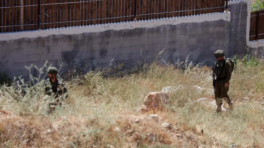 Israeli-soldiers-walk-near-the-site-of-a-residential-building-demolition-unseen-in-the-village-of-Khirbet-Qalqas-south-of-Hebron-in-the-occupied-West-Bank-on-June-8-2026-The-Israeli-army-demolished-the-six-apartment-building-which-housed-16-people-citing-a-lack-of-building-permits-in-Area-C
