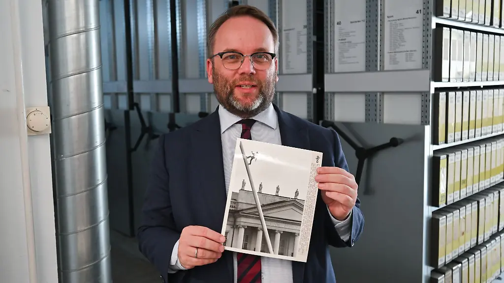 Timon-Gremmels-SPD-Hessens-Minister-fuer-Kunst-und-Kultur-haelt-ein-Foto-einer-frueheren-documenta-in-Kassel-in-den-Haenden