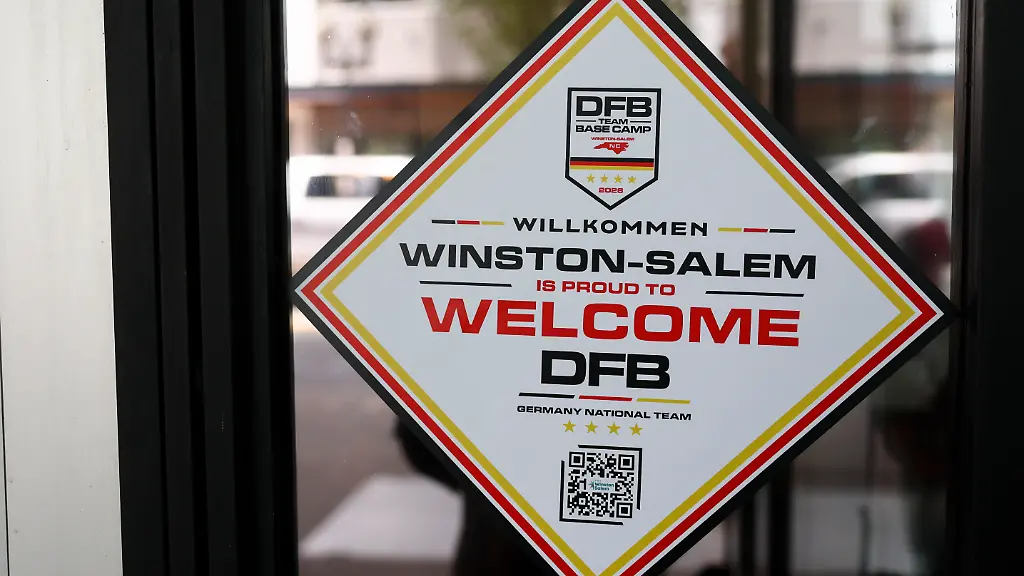 Ein-Aufkleber-auf-der-Tuer-zu-einem-Cafe-heisst-die-Deutsche-Nationalmannschaft-willkommen-Am-Montag-08-06-wird-die-Deutsche-Nationalmannschaft-ihr-Mannschaftsquartier-fuer-die-Vorrunde-in-der-Stadt-beziehen