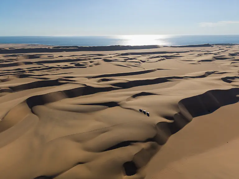 Luftaufnahme-von-Gelaendewagen-und-Sandduenen-im-Dorob-Nationalpark-aufgenommen-waehrend-der-Little-Five-Desert-Safari-nahe-Swakopmund-Erongo-Namibia