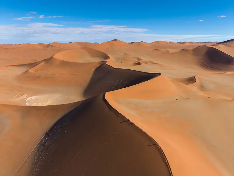 Luftaufnahme-von-Menschen-beim-Wandern-auf-riesigen-roten-Sandduenen-in-der-Namib-Wueste-Namib-Naukluft-Nationalpark-Hardap-Namibia