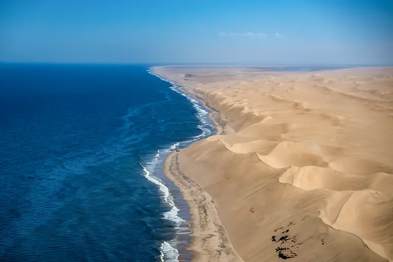 Luftaufnahme-von-Sandduenen-in-der-Namib-Wueste-und-der-Kuestenlinie-des-Suedatlantiks-aufgenommen-waehrend-eines-Rundflugs-nahe-Walvis-Bay-Erongo-Namibia