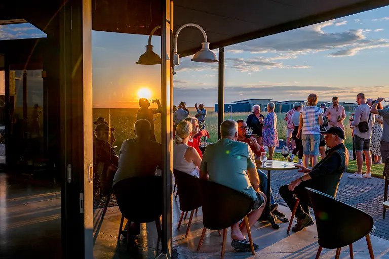 Gaeste-geniessen-eine-Happy-Hour-bei-Sonnenuntergang-auf-der-Terrasse-des-Restaurants-der-stilvollen-Etosha-King-Nehale-Lodge-Gondwana-Collection-nahe-dem-Etosha-Nationalpark-Oshikoto-Namibia