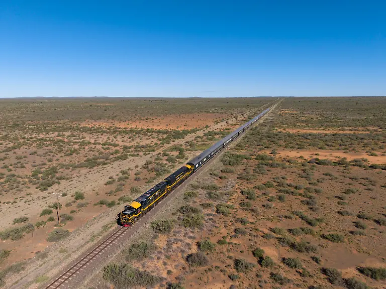 Luftaufnahme-des-luxurioesen-Boutique-Zuges-African-Explorer-von-Rovos-Rail-Lernidee-Erlebnisreisen-in-karger-Landschaft-Siyathemba-NU-Nordkap-Suedafrika