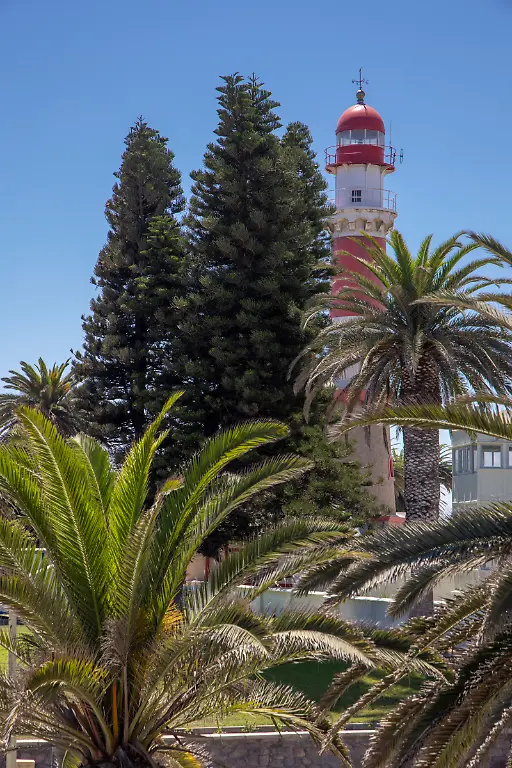 Luftaufnahme-von-Palmen-und-dem-markanten-rot-weiss-gestreiften-Leuchtturm-der-1902-erbaut-wurde-und-28-Meter-hoch-ist-Swakopmund-Erongo-Namibia