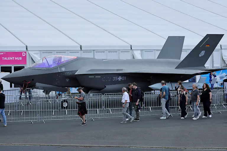 Visitors-walk-past-a-mockup-presentation-of-Lockheed-Martin-F-35-multirole-strike-fighter-jet-during-the-International-Aerospace-Exhibition-ILA-at-Schoenefeld-Airport-in-Berlin-Germany-June-10-2026