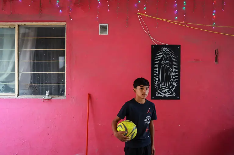 Humberto-Guadalupe-14-nicknamed-Messi-who-dreams-of-becoming-a-professional-soccer-player-poses-for-a-portrait-next-to-the-image-of-the-Virgin-of-Guadalupe-at-his-house-in-Cerro-de-la-Campana-Monterrey-Mexico-March-28-2026-REUTERS-Raquel-Cunha-SEARCH-CUNHA-MEXICO-SOCCER-FOR-THIS-STORY-SEARCH-WIDER-IMAGE-FOR-ALL-STORIES