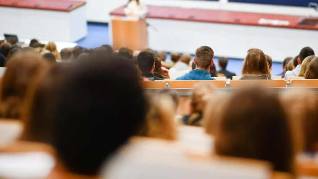 Studenten-sitzen-in-der-Universitaet-bei-der-Begruessung-der-Erstsemester-Studenten-in-einem-Hoersaal