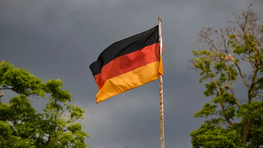 Die-deutsche-Flagge-weht-vor-dunklen-Wolken-im-Wind