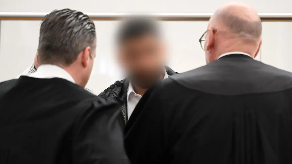 Der-Angeklagte-mit-zwei-Strafverteidigern-vor-Beginn-des-Prozesses-am-9-April