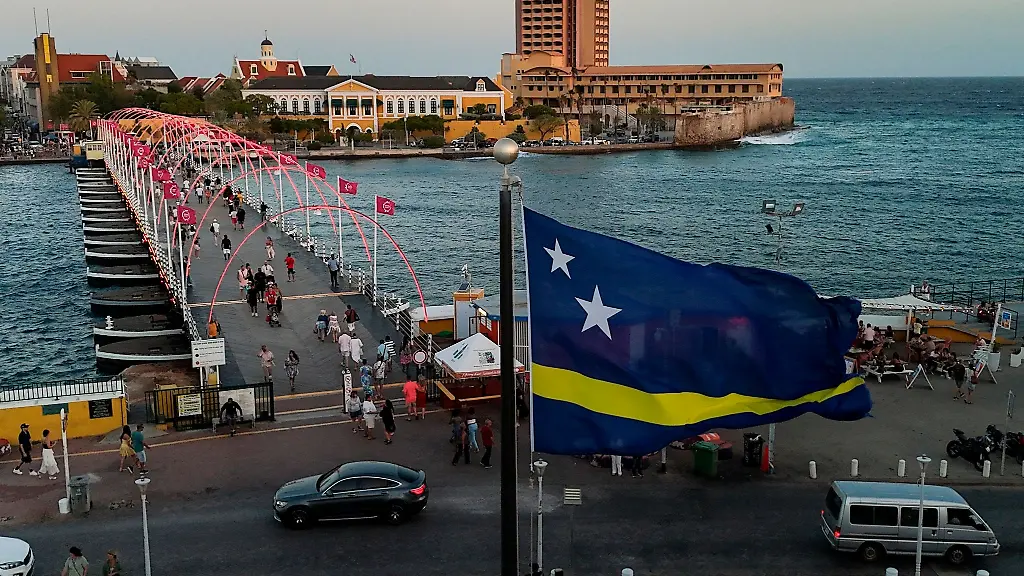 Eine-Flagge-von-Curacao-weht-in-Willemstad-neben-der-schwimmenden-Koenigin-Emma-Bruecke