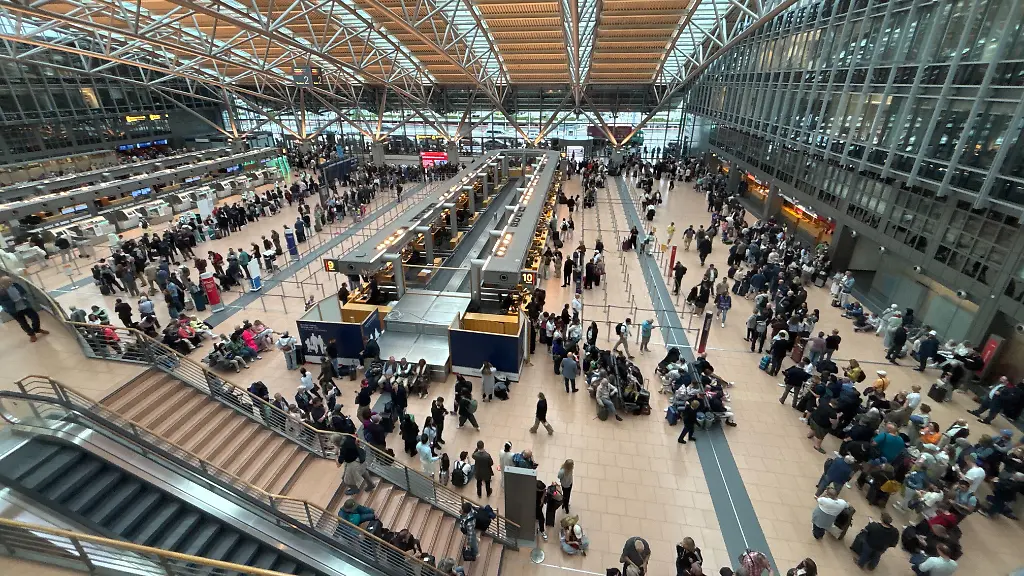 Zahlreiche-Menschen-stehen-im-Terminal-des-Hamburger-Flughafens-Wegen-einer-polizeilichen-Lage-am-Hamburger-Flughafen-ist-der-Sicherheitsbereich-des-Airports-geraeumt-worden